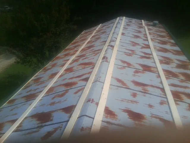Rusted metal roof panels with new wood purlins before replacement — Storm Damage Roof Repair in Grove City by Roofing Brothers