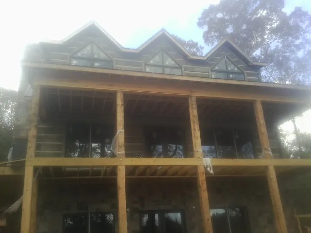 Dormers and porch framing on a large log home under construction — Roof Coating work by our crew in Grove City