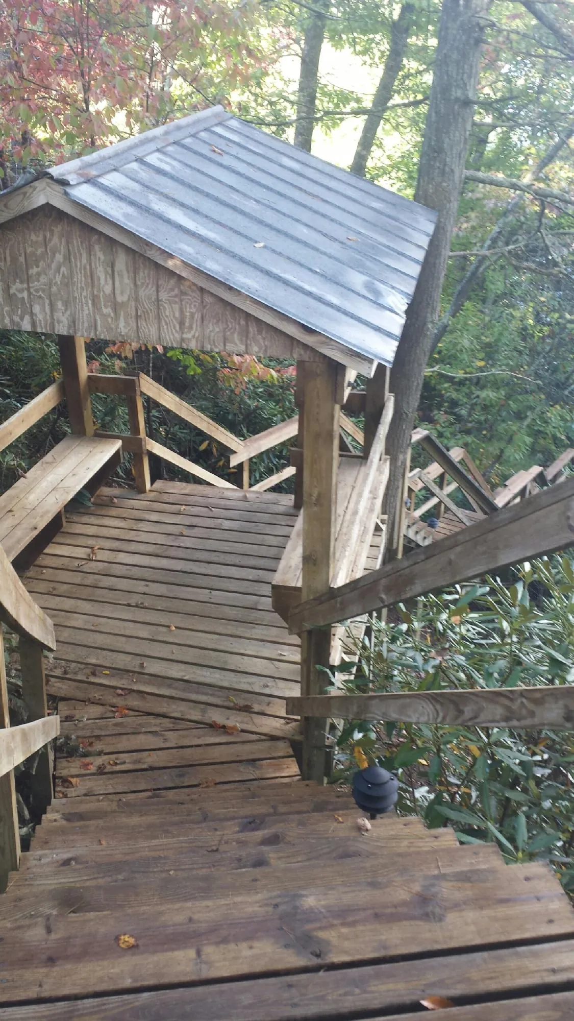 Metal roofed shelter over wooden steps on a wooded walkway — Skylight Repair & Installation work by our crew in Grove City