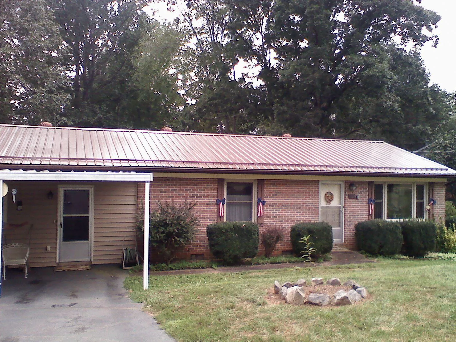 Bronze metal roof and carport on a brick ranch home — Roof Repair work by our crew in Grove City
